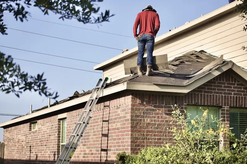 Professional roofer working on a residential roof in North Village